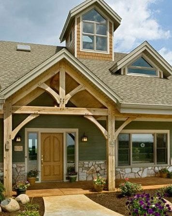 entrance of timber frame home with a large natural timber frame porch