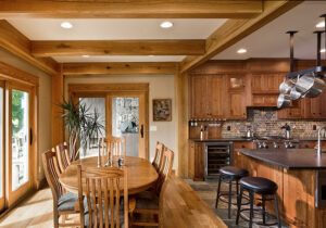 dining room and kitchen of a timber frame home with exposed post and beam framing