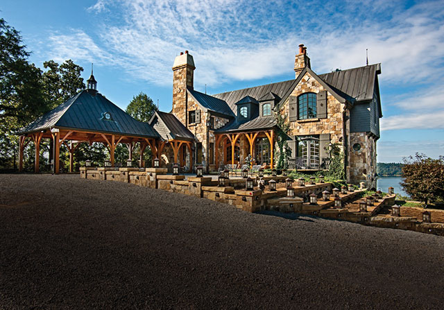 timber frame home with stone exterior and outdoor timber frame patio