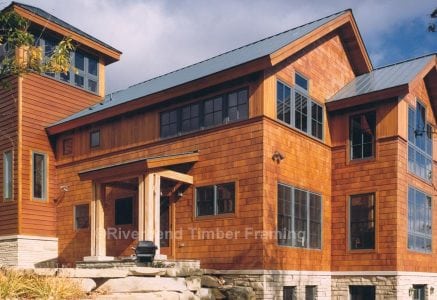 timber frame home with natural stained wood exterior and stone foundation