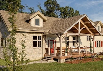 timber frame home with large timber framing over front deck