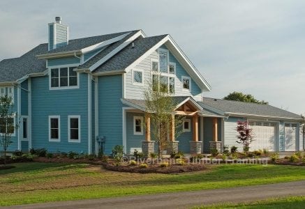 timber frame home with light blue exterior and a two car garage