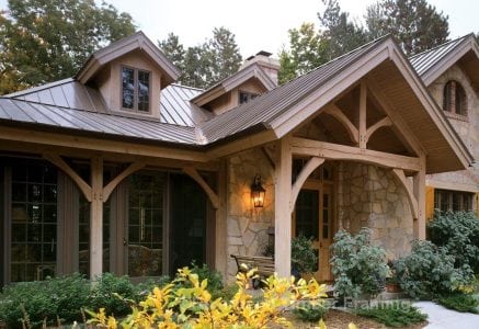 timber frame european style home front with covered wrap around porch